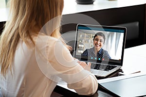 Businesswoman having distant negotiations using video conference application on pc