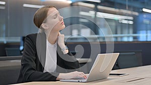 Businesswoman having Neck Pain while Typing on Laptop