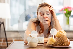 Businesswoman having sensitivity to dairy and pastry products photo