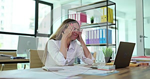 Businesswoman with headache after working on laptop in office