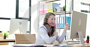 Businesswoman in headphones with microphone communicating via video link using computer 4k movie