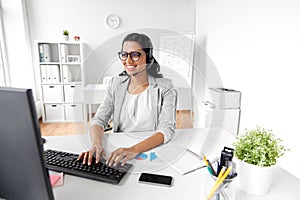 Businesswoman with headset and computer at office