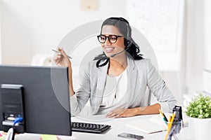 Businesswoman with headset and computer at office