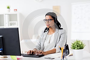 Businesswoman with headset and computer at office