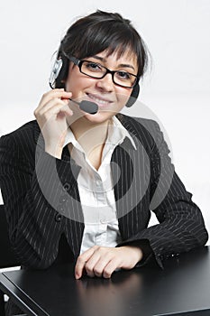 Businesswoman with headset sitting at desk