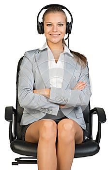 Businesswoman in headset sitting on office chair