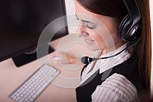 Businesswoman with headset working on computer