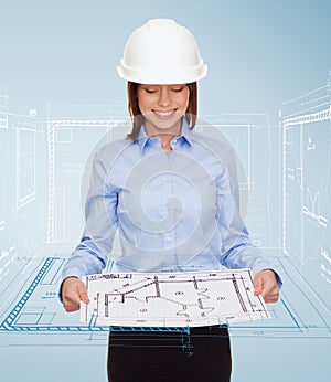Businesswoman in helmet looking at blueprint