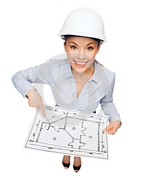 Businesswoman in helmet showing with blueprint