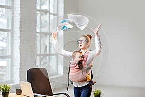 Businesswoman with her baby son working with documents at the office