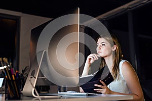 Businesswoman in her office at night working late.