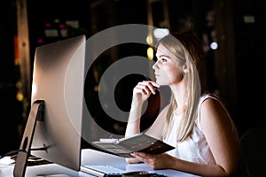 Businesswoman in her office at night working late.