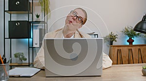 Businesswoman hiding behind laptop computer, making funny face fooling around putting his tongue out