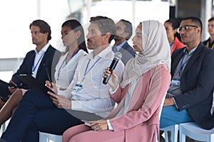 Businesswoman in hijab asking question during seminar