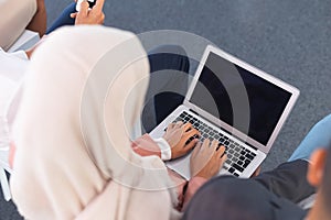 Businesswoman in hijab working on laptop in business seminar