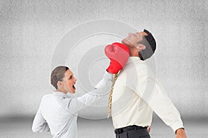 Businesswoman hitting a businessman with boxing gloves
