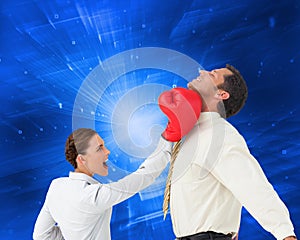 Businesswoman hitting a businessman with boxing gloves