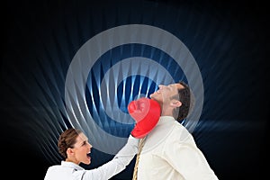 Businesswoman hitting a businessman with boxing gloves