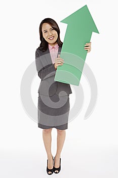 Businesswoman holding an arrow, pointing upwards