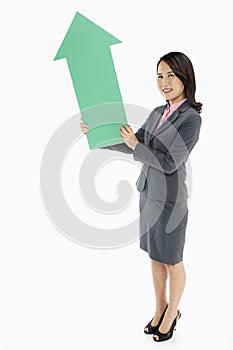 Businesswoman holding an arrow, pointing upwards