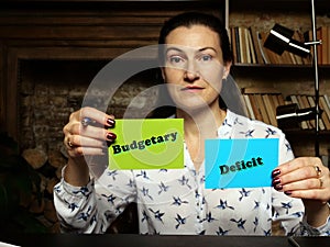 BusinessWoman holding a blank business cards. Business concept about Budgetary Deficit with phrase on the sheet