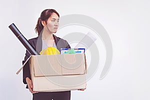 Businesswoman holding box leaving office after quitting job