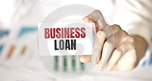 Businesswoman holding a card with text BUSINESS LOAN