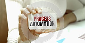 Businesswoman holding a card with text PROCESS AUTOMATION