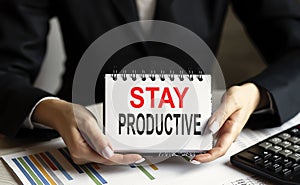 Businesswoman holding card with text Stay productive concept on chart