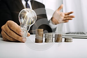 Businesswoman holding coins putting in glass with using smartphone and calculator to calculate concept saving money for finance ac