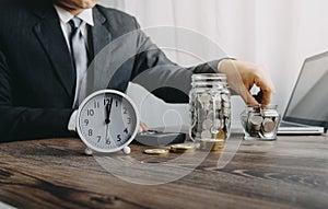 Businesswoman holding coins putting in glass with using smartphone and calculator to calculate concept saving money for finance ac