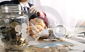 Businesswoman holding coins putting in glass with using smartphone and calculator to calculate concept saving money for finance ac