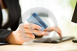 Businesswoman holding credit card on laptop for online payment concept