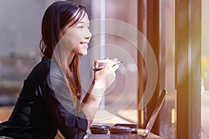 Businesswoman holding a cup of coffee relaxing sitting in the office