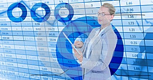 Businesswoman holding digital tablet standing by numerical background