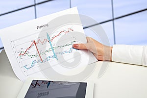 Businesswoman holding graph in her hand . The digital tablet is