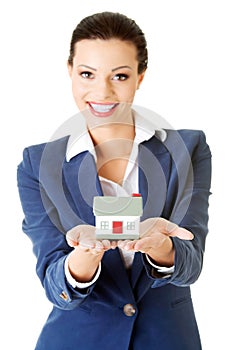 Businesswoman holding house model - real estate loan concept