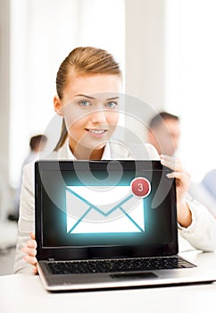 Businesswoman holding laptop with email sign