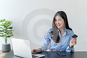 Businesswoman holding mock up credit card with number working from home online shopping, e-commerce, internet banking.