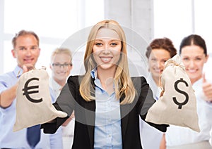 Businesswoman holding money bags with dollars