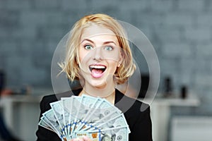 Businesswoman holding money with delight