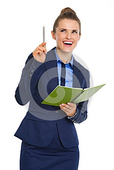 Businesswoman holding open notebook and pen having aha moment