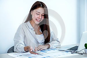 Businesswoman holding pen and analysis the chart with laptop at the office for setting challenging business goals And planning to