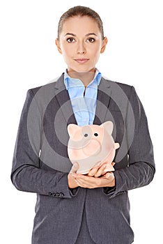 Businesswoman holding a piggy bank