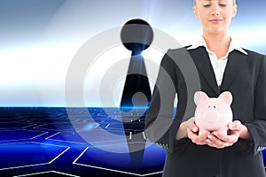 Businesswoman holding piggy bank