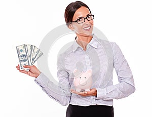 Businesswoman holding piggy bank and dollar bills