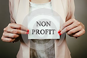 Businesswoman holding sheet of paper with text non profit