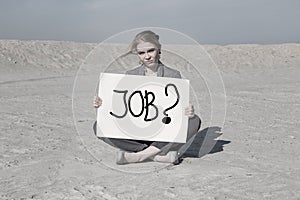 Businesswoman holding a sign in search of work. Financial crisis. Unemployment. A man in a business suit in the desert.