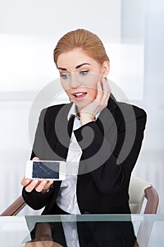 Businesswoman holding smartphone with cracked screen