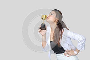 Businesswoman holding trophy award for success in business ,isolated on gray background